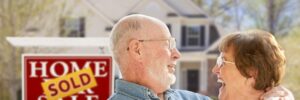 Senior couple standing outside of their newly sold home