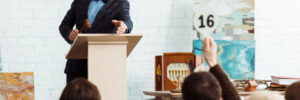 selective focus of auctioneer holding gavel and pointing with finger at buyer during auction