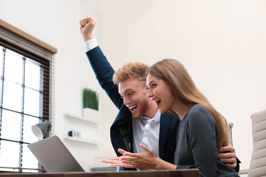 Happy young couple winning online auction